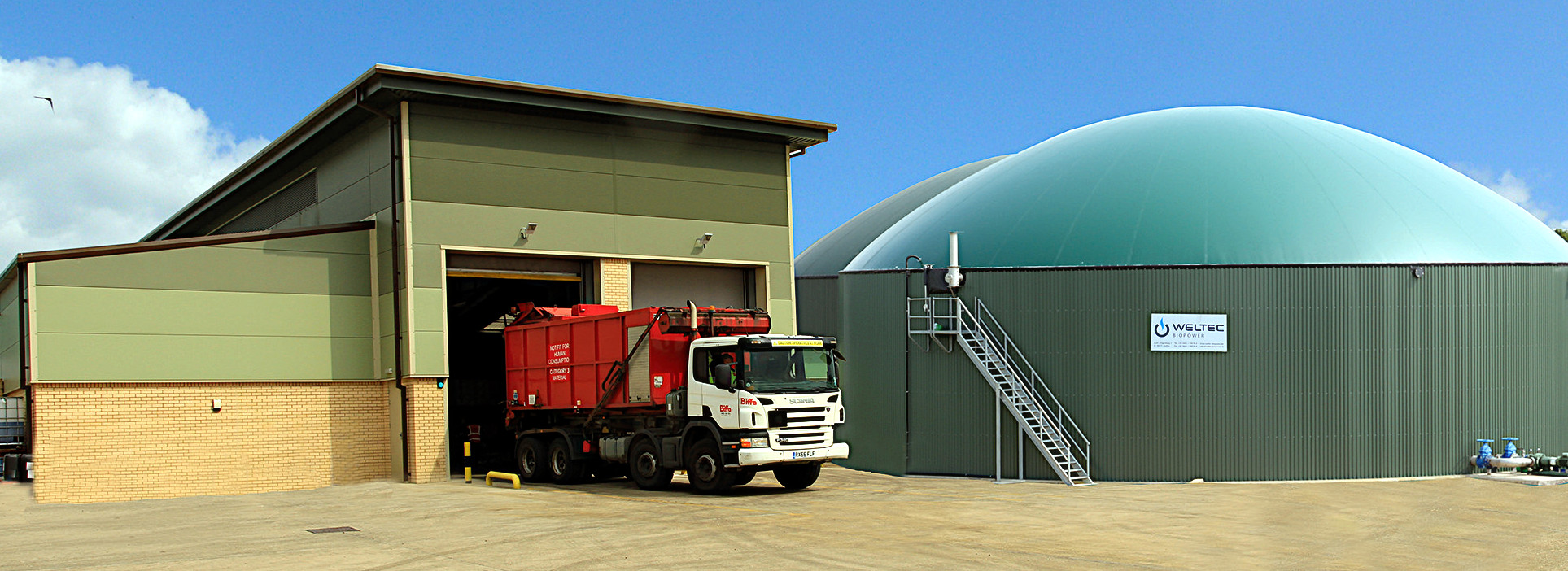 Waste truck in front of organic waste treatment plant.
